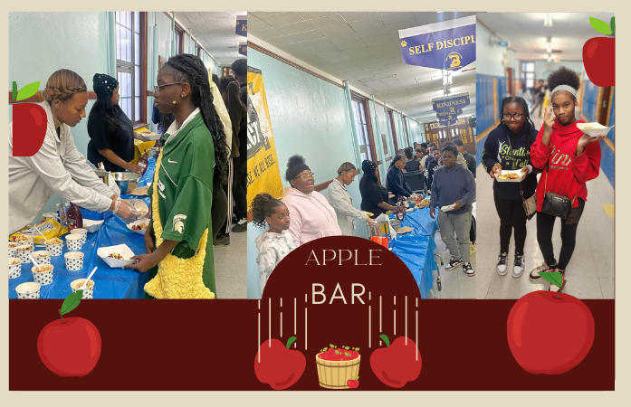  Students lined up in the hallway to get Apples from staff, 2 girls hold whait containers